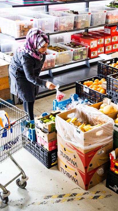 Vrouw doet boodschappen bij de voedselbank