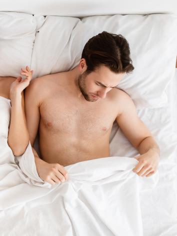 man kijkt onder de dekens 