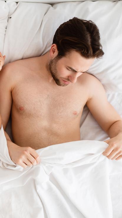 man kijkt onder de dekens 