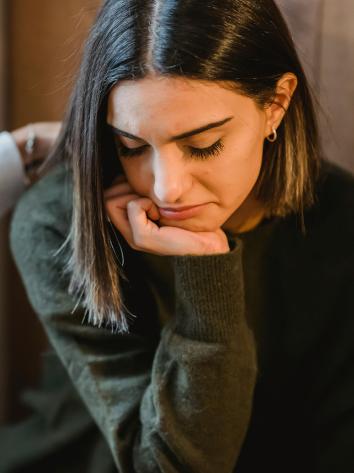 iemand kijkt somber naar beneden met een hand onder de kin