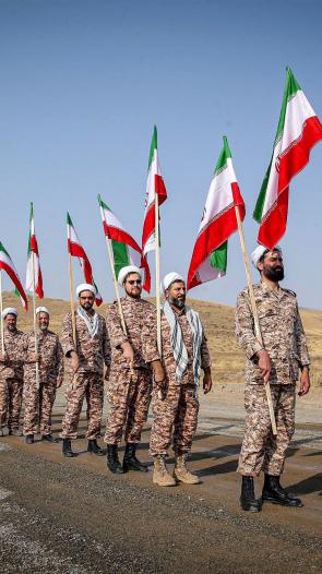 soldaten van de Iraanse Revolutionaire Garde lopen met vlaggen