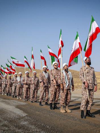 soldaten van de Iraanse Revolutionaire Garde lopen met vlaggen