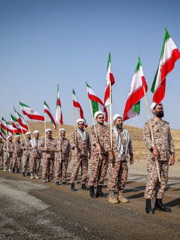 soldaten van de Iraanse Revolutionaire Garde lopen met vlaggen
