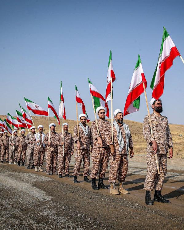 soldaten van de Iraanse Revolutionaire Garde lopen met vlaggen