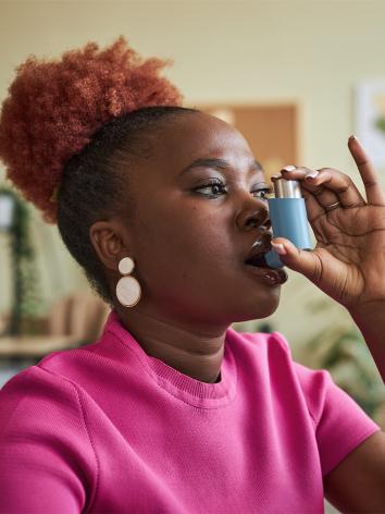 Vrouw neemt puf als astma-medicatie