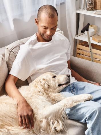 een man relaxt met zijn retriever hond op de bank