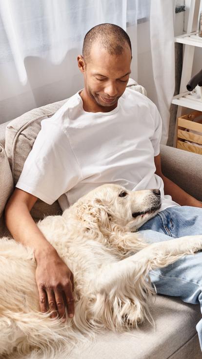 een man relaxt met zijn retriever hond op de bank