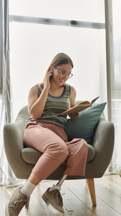 iemand leest thuis een boek in een stoel bij het raam