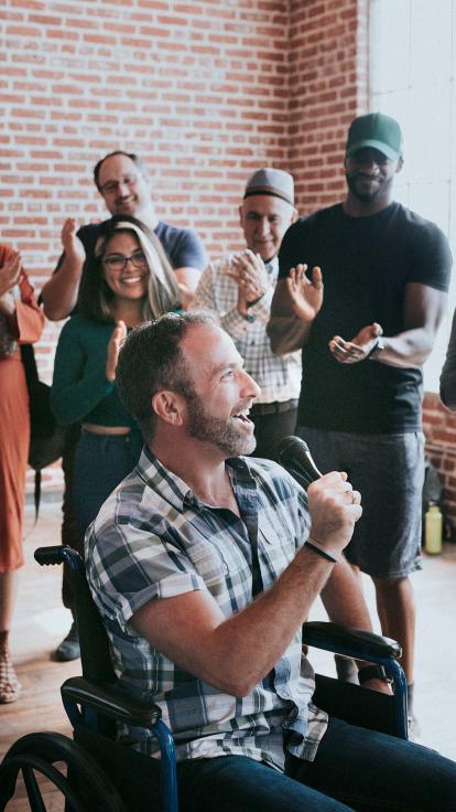 iemand spreekt voor een groep applaudiserende mensen 