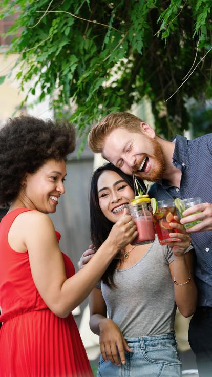 een groepje mensen staat te praten, lachen en drinken samen