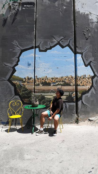 Een kunstwerk op de Israëlische muur bij Bethlehem