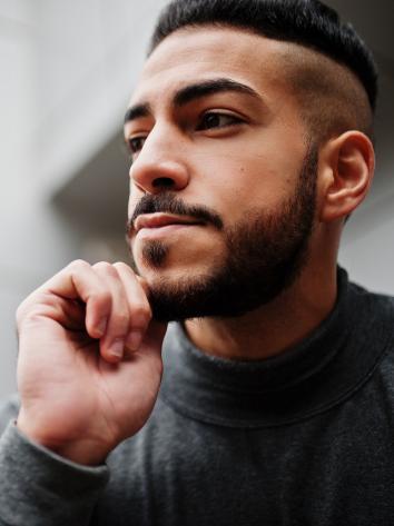 iemand kijkt voor zich uit met zijn hand op zijn kin