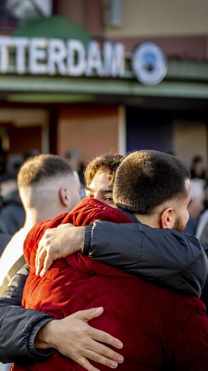 Twee jongens omhelzen elkaar na het ochtendgebed