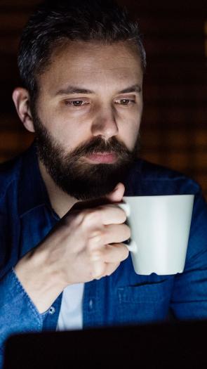 Iemand drinkt koffie in de avond