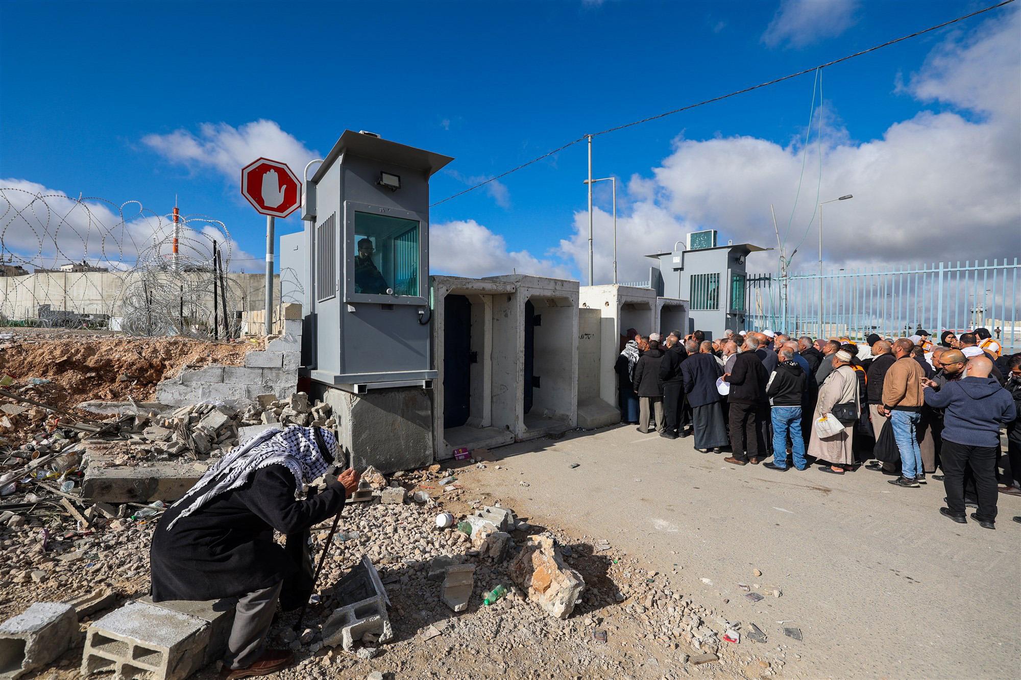 Palestijnse mannen wachten voor het militaire checkpoint Qalandia op de westoever