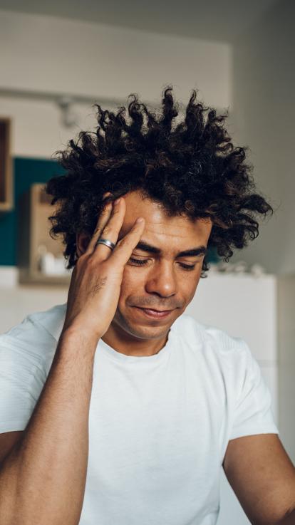 Man grijpt peinzend naar zijn hoofd