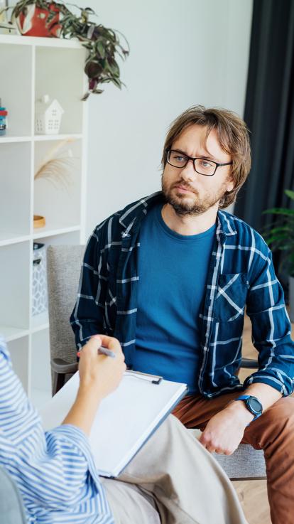Therapiesessie waar een vrouw vragen stelt aan een man