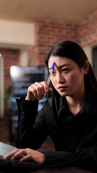 Vrouw kijkt geconcentreerd naar computerscherm