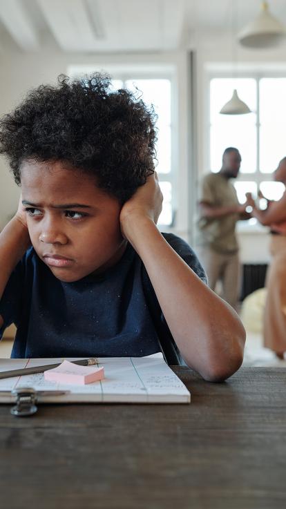 Kind kijkt weg met handen over oren