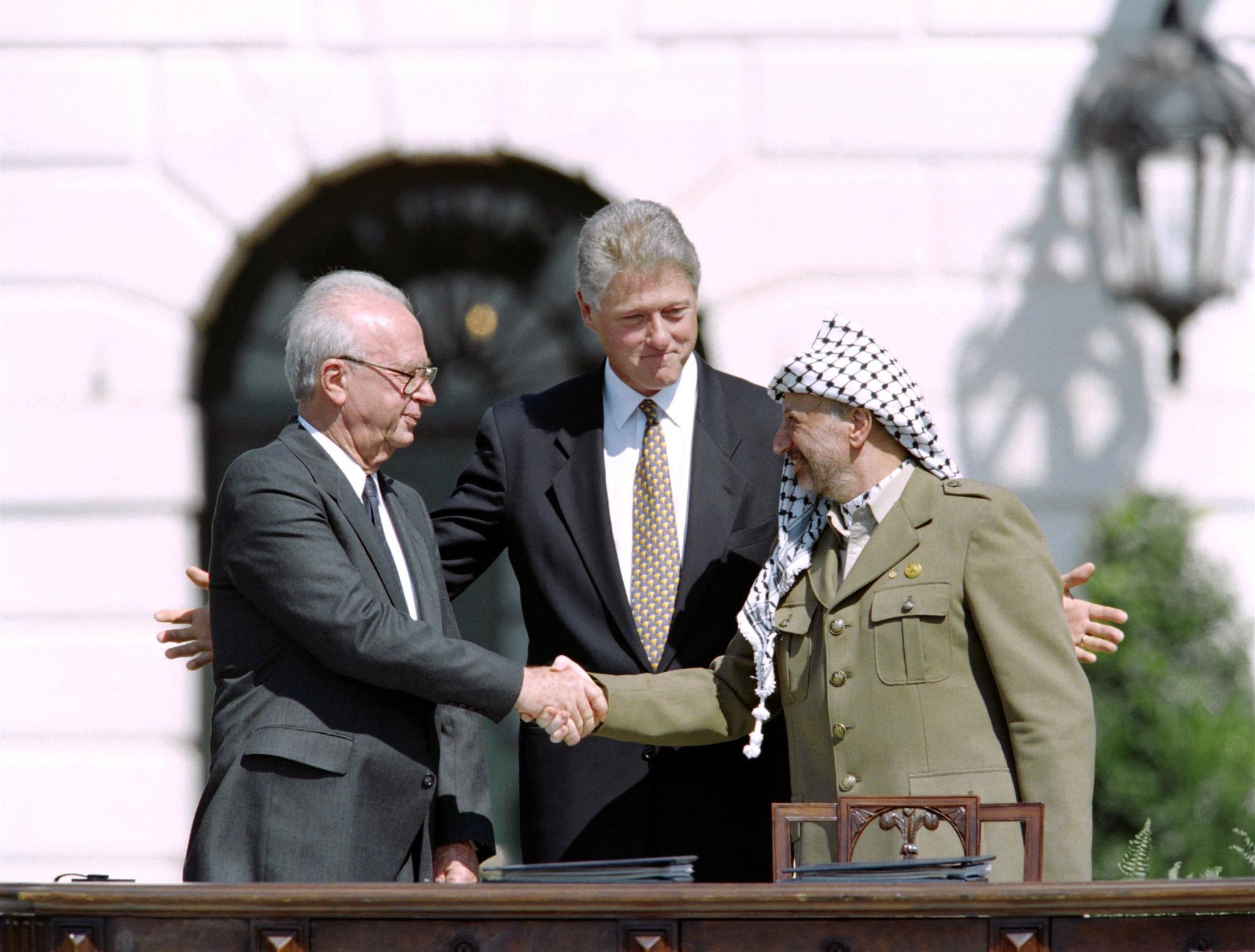 Rabin en Arafat schudden de hand, Clinton staat erachter