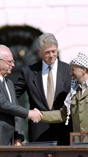 Rabin en Arafat schudden de hand, Clinton staat erachter