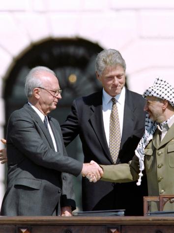 Rabin en Arafat schudden de hand, Clinton staat erachter