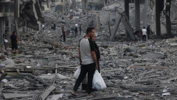 Palestijnen staan tussen de brokstukken na bombardementen op Gazastad