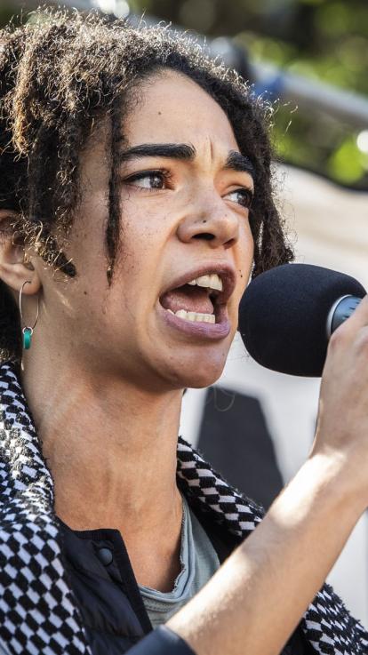 een deelnemer aan een protest spreekt in een microfoon