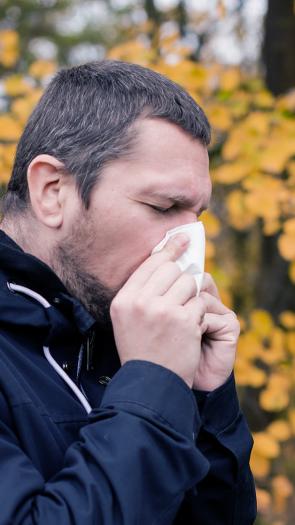 man snuit buiten zijn neus