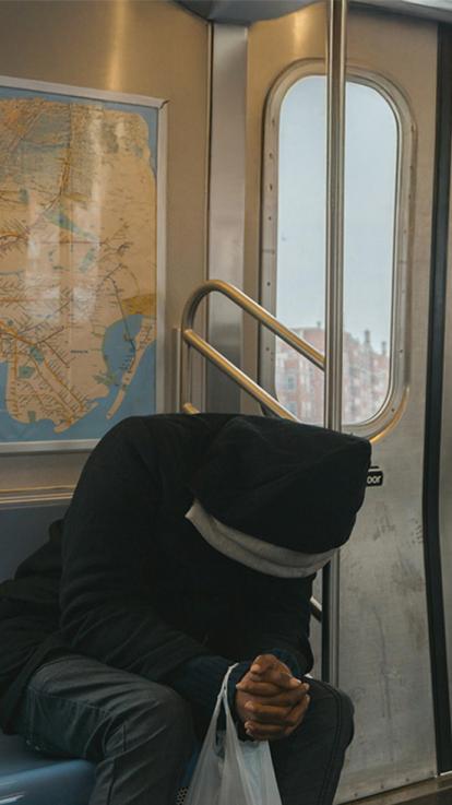 Eenzaam persoon in de train met zijn must op. 