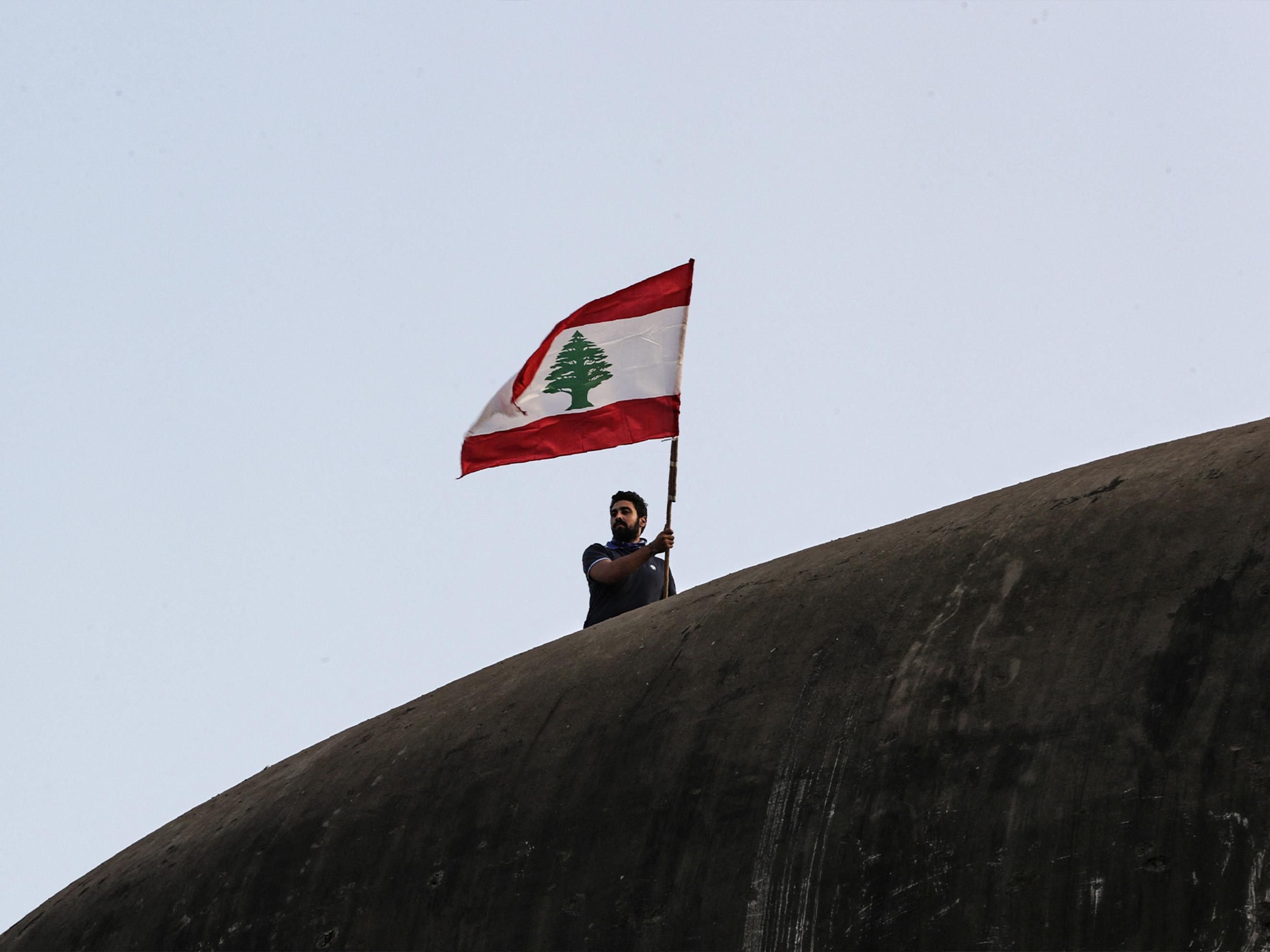 Man zwaait met Libanese vlag tijdens de protesten in 2019