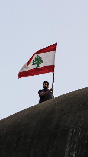 Man zwaait met Libanese vlag tijdens de protesten in 2019