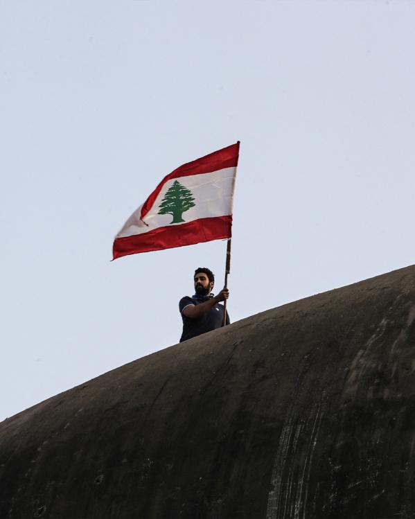Man zwaait met Libanese vlag tijdens de protesten in 2019