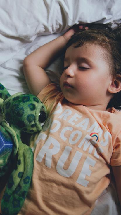 een kind ligt te slapen met z'n knuffel