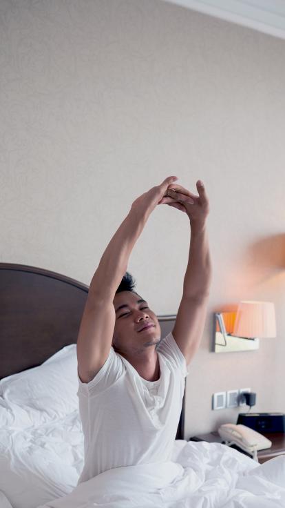 iemand rekt zich uit in bed