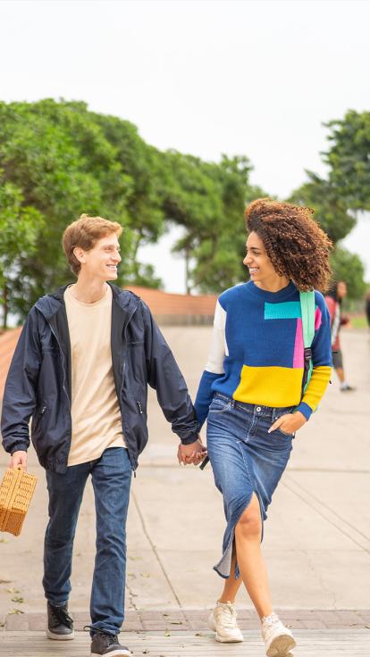 een koppel loopt hand in hand op straat