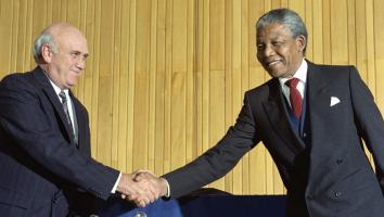 Nelson Mandela (r) en Frederik Willem de Klerk (l) schudden elkaar de hand