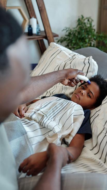 Een vader meet de temperatuur op van zijn kind