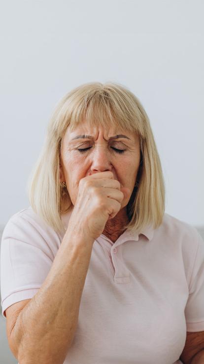 een oudere vrouw aan het hoesten