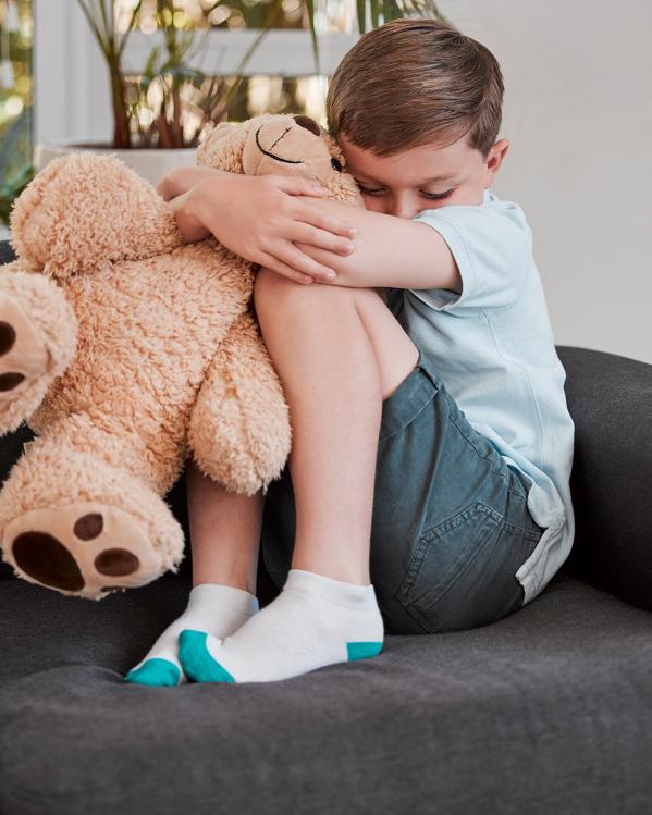 een kind knuffelt z'n teddybeer