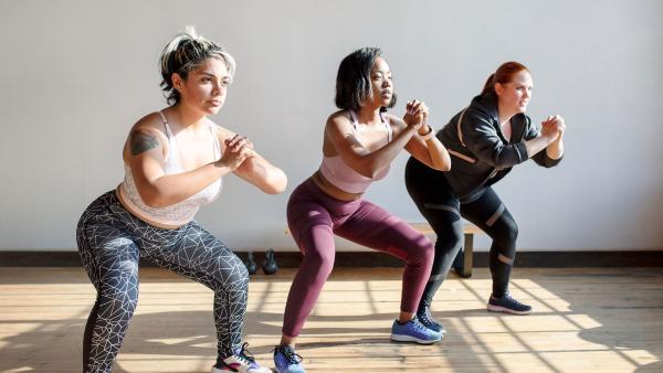 drie personen in de sportschool doen oefeningen