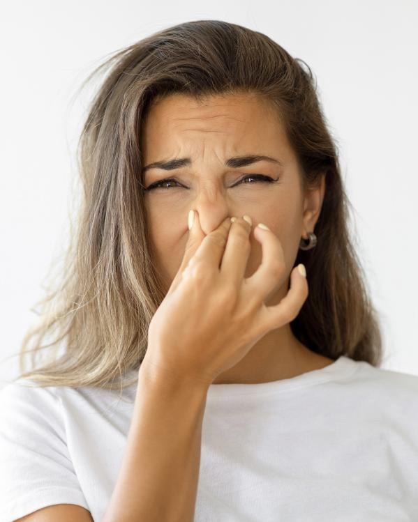 iemand knijpt haar neus dicht vanwege stank