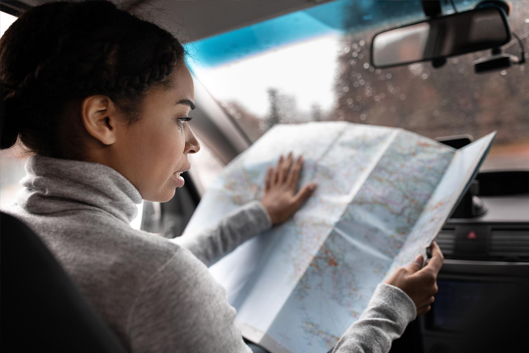 Vrouw kijkt in de auto op een landkaart