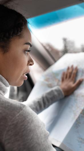 Vrouw kijkt in de auto op een landkaart