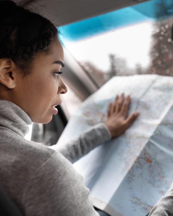 Vrouw kijkt in de auto op een landkaart