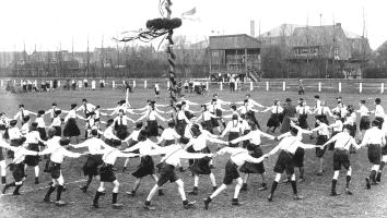 Leden van de Nationale Jeugdstorm dansen om een meiboom voor de 1 mei viering