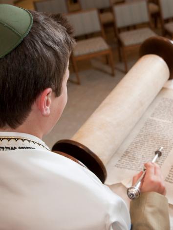 een jongen leest de Tora voor zijn Bar Mitzvah