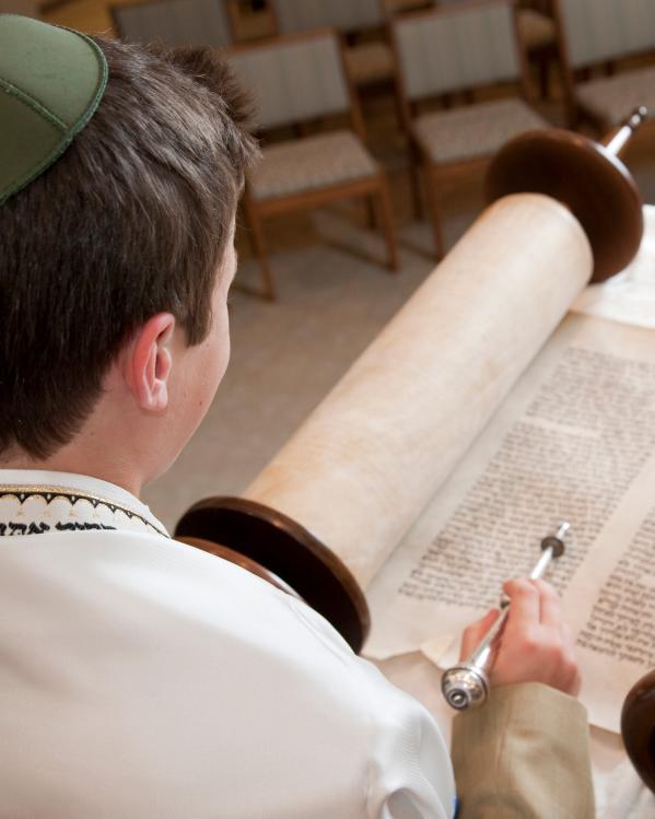 een jongen leest de Tora voor zijn Bar Mitzvah