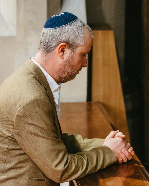 een man aan het bidden in een synagoge