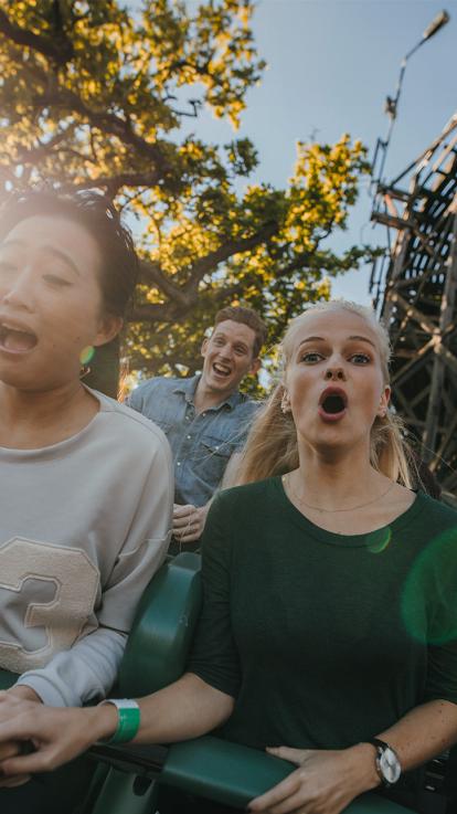 Mensen zitten in een achtbaan en kijken geschokt